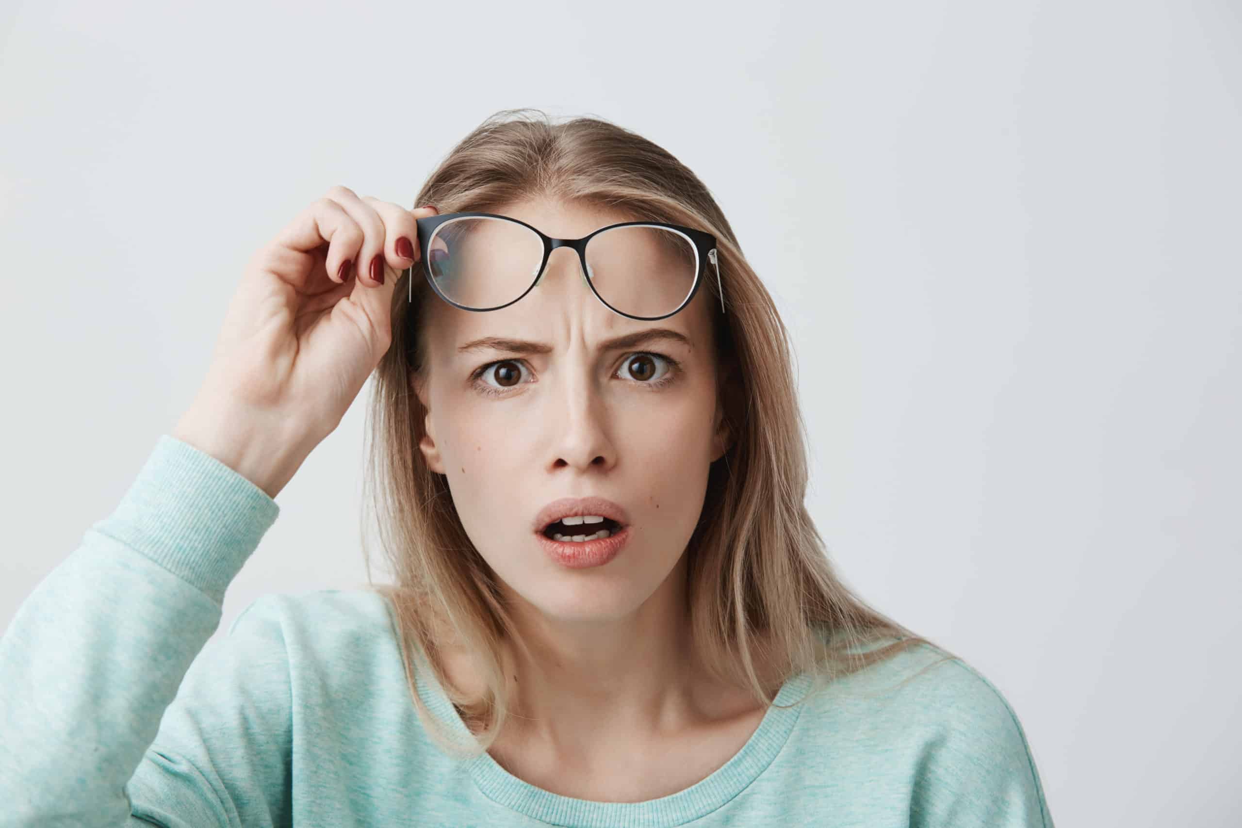Surprised Young Female Model With Long Blonde Hair Wears Glasses